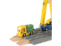 Camion jouet et grue jaune sur rails en bois, avec un ouvrier dans le camion.