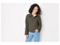 Une femme portant une veste vert foncé et un jean bleu.