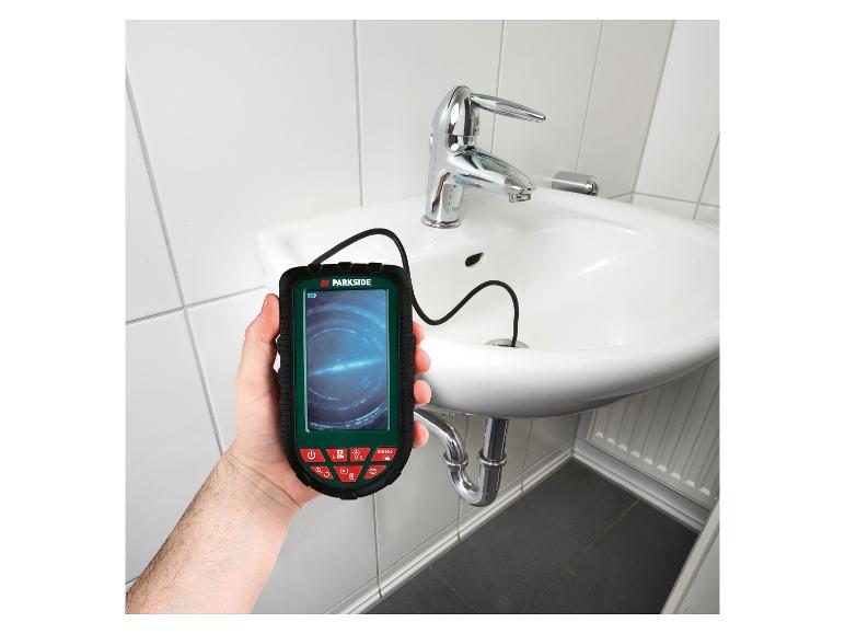 Endoscope d'inspection numérique tenu à la main, avec une caméra insérée dans un lavabo de salle de bain.