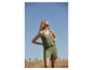 Une femme portant une combinaison verte dans un champ.