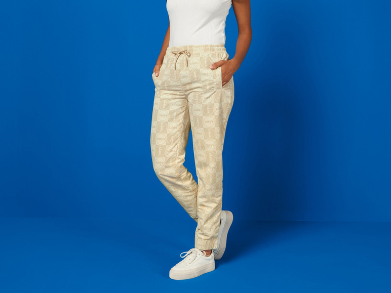 Pantalon beige avec imprimé Lidl et baskets blanches.