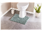 Tapis de bain vert menthe et brosse de toilette dans une salle de bain moderne.