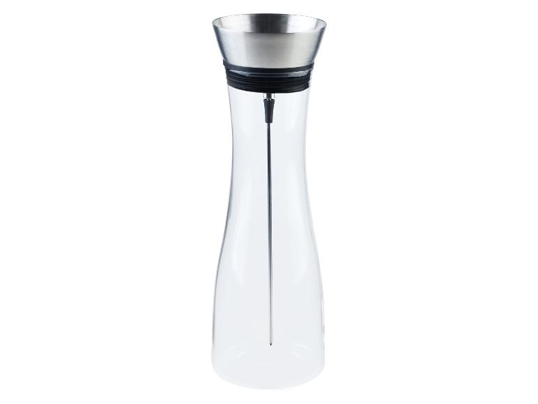 Une carafe en verre avec un couvercle en métal et une tige pour infuser du thé.