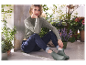 Femme en bottes Hunter assise dans un jardin.