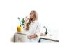 Femme enceinte buvant de l'eau filtrée dans la cuisine à côté d'une carafe BRITA Marella.