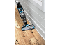Aspirateur nettoyeur de sol nettoyant des taches sombres sur un parquet.