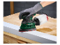 Une main gantée utilise une ponceuse orbitale Parkside pour poncer une surface en bois.