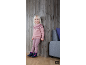 Fillette vêtue d'un pull en tricot rose, d'un legging et de bottes d'hiver.