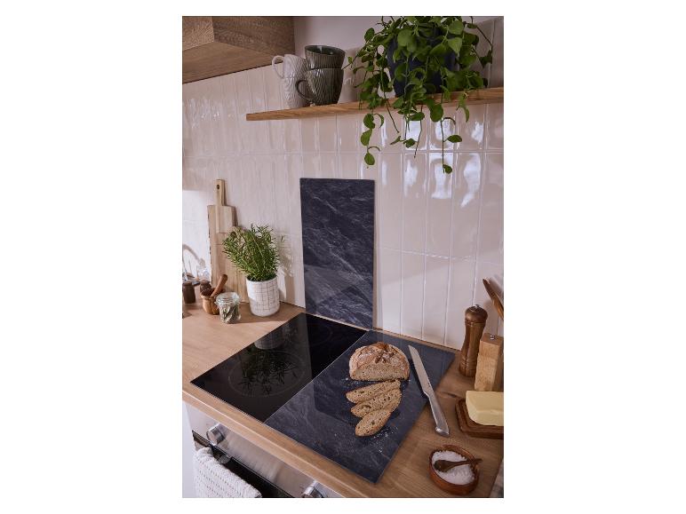 Plan de travail de cuisine avec plaque à induction, planche à découper avec pain, beurre et épices.