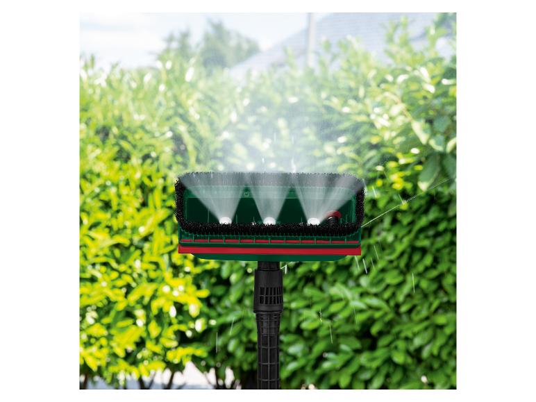 Brosse de jardin avec fonction de pulvérisation d'eau sur fond de haie verte