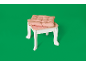 Tabouret d'enfant avec coussin rose sur fond vert.