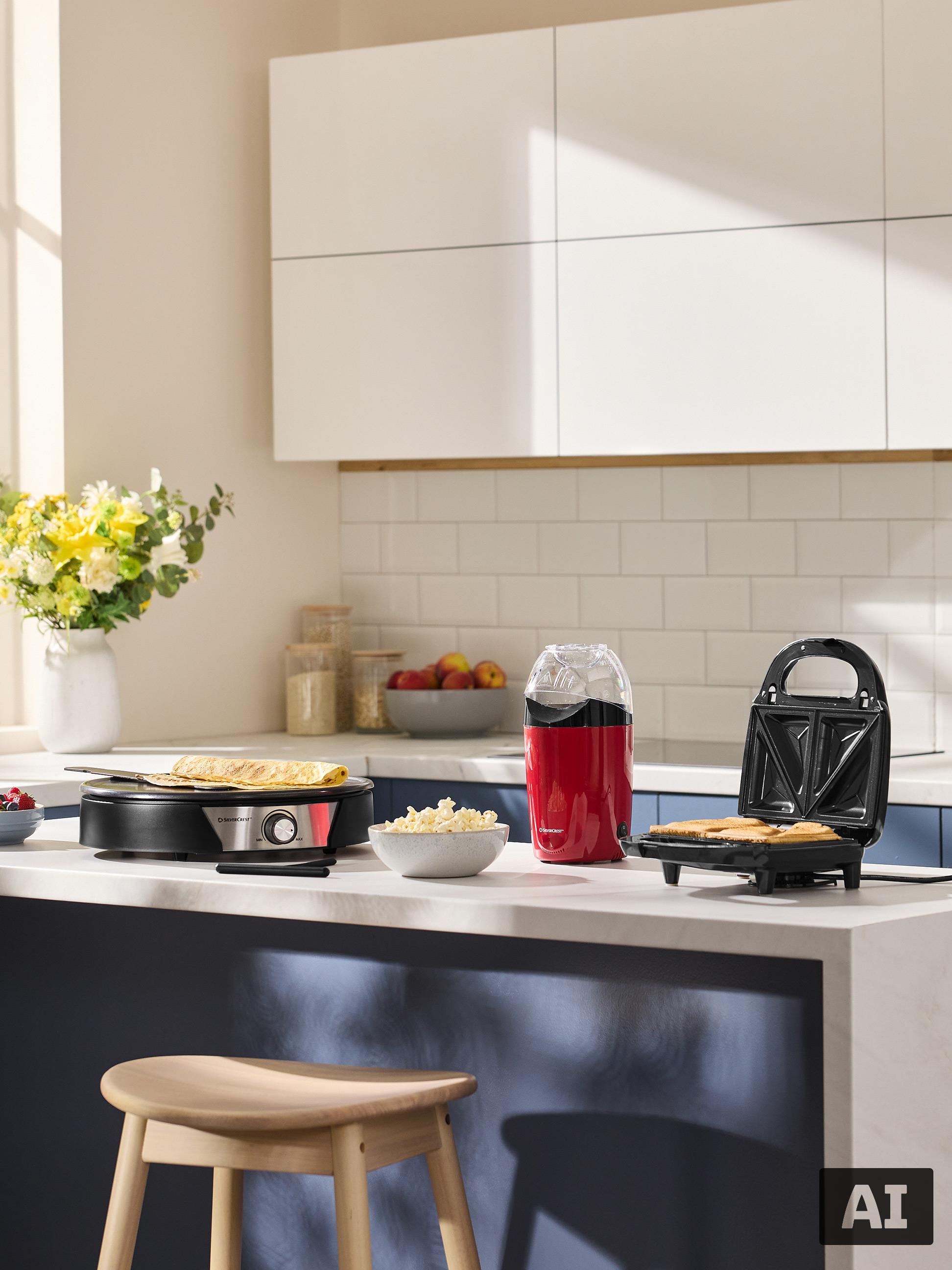 Cuisine avec crêpière, gaufrier et machine à popcorn, prête pour le petit-déjeuner.