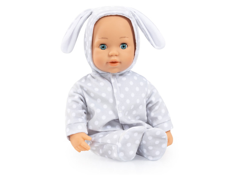 Une poupée bébé avec des oreilles de lapin, vêtue d'une tenue grise à pois blancs.