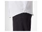 Chemise blanche à manches longues et pantalon noir.