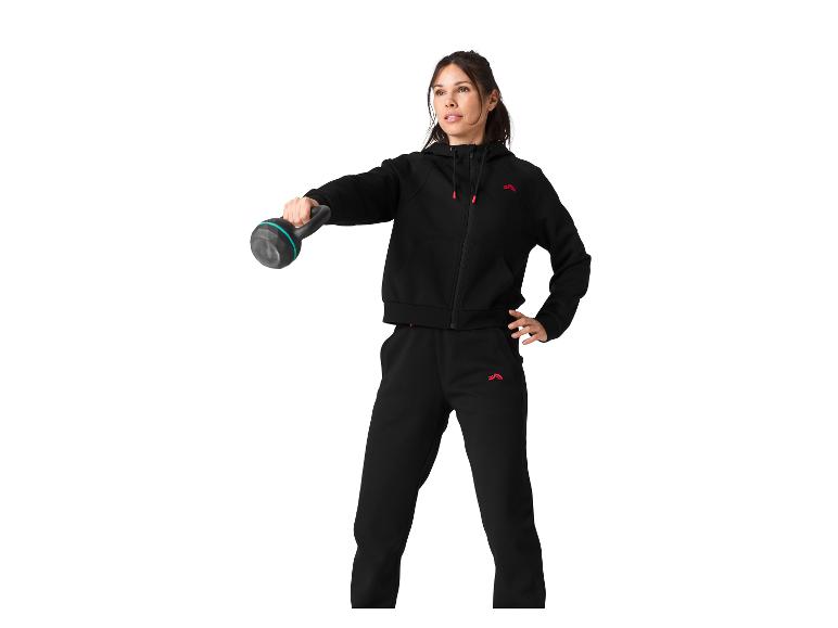 Femme en survêtement noir avec kettlebell.