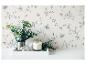 Mur avec motif floral, eucalyptus dans un pichet, une bougie allumée et une figurine de lapin sur un plateau.