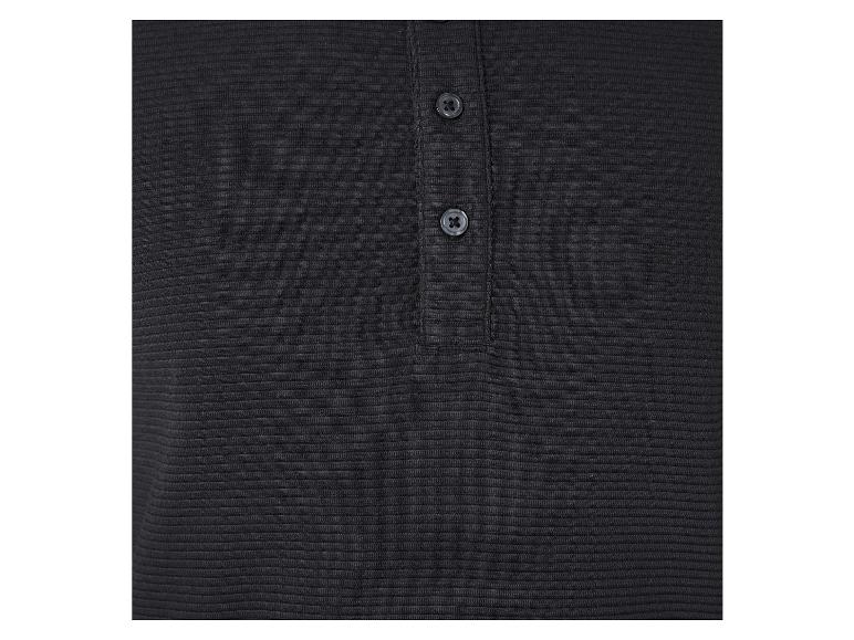 Gros plan sur un polo noir à boutons.