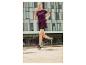 Femme courant en t-shirt et short de sport, chaussures de running.