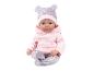 Poupée bébé vêtue d'un sweat à capuche rose et d'un pantalon à motifs avec un bonnet assorti.