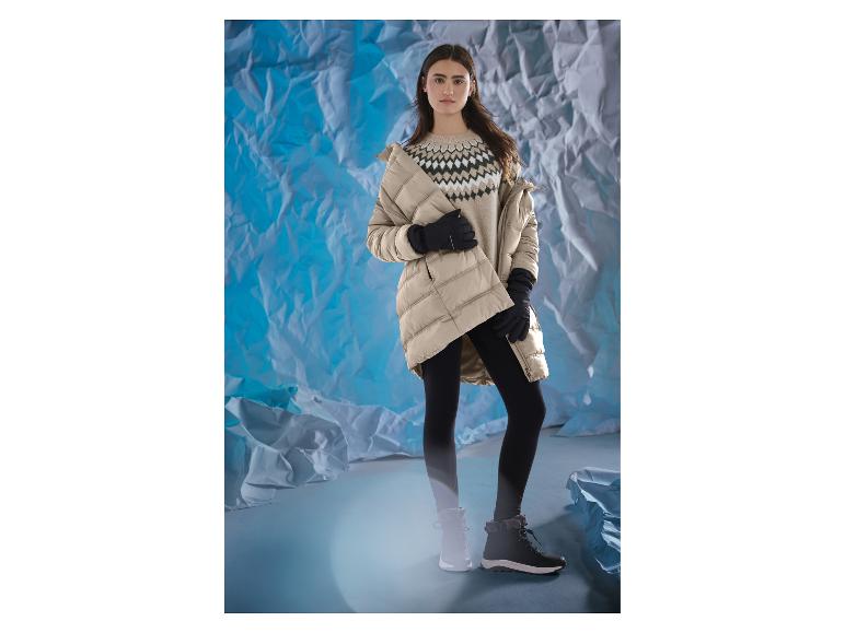 Femme en veste beige, pull à motifs, leggings noirs et bottes d'hiver