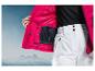 Veste de ski rose avec poche intérieure et pantalon de ski blanc.