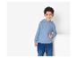Un garçon portant un sweat à capuche bleu et un jean.