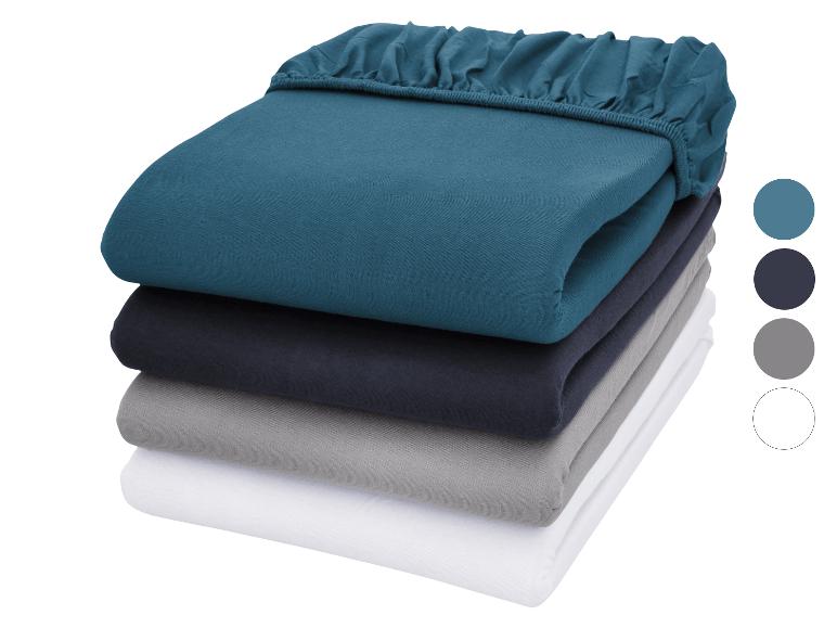 Draps housses empilés en bleu, bleu marine, gris et blanc avec échantillons de couleurs.