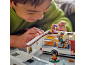 Enfant jouant avec un camping-car jouet et des figurines miniatures.