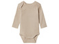 Un body bébé à manches longues de couleur beige