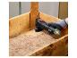 Une main utilisant un outil multifonction Parkside pour poncer du bois.