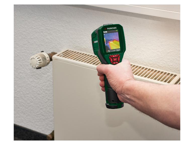 Un homme utilise une caméra thermique pour vérifier un radiateur, affichant 53,6°C.