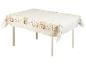 Une table blanche avec une nappe à motif de lapins et de fleurs.