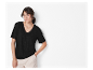 Modèle portant un t-shirt noir et un pantalon beige.