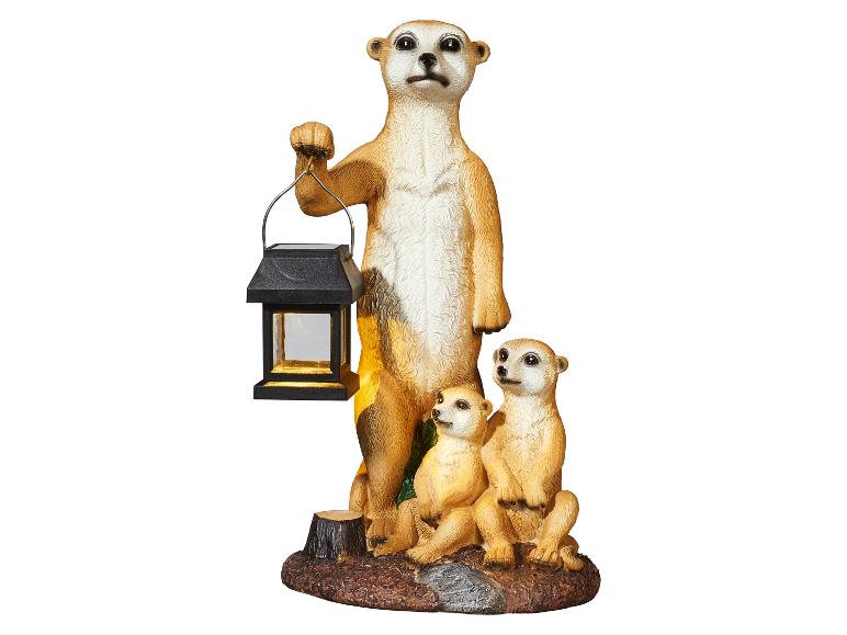 Figurine décorative d'une famille de suricates, l'adulte tenant une lanterne solaire.