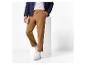 Homme en pantalon marron et veste bleu foncé avec T-shirt blanc et baskets blanches.