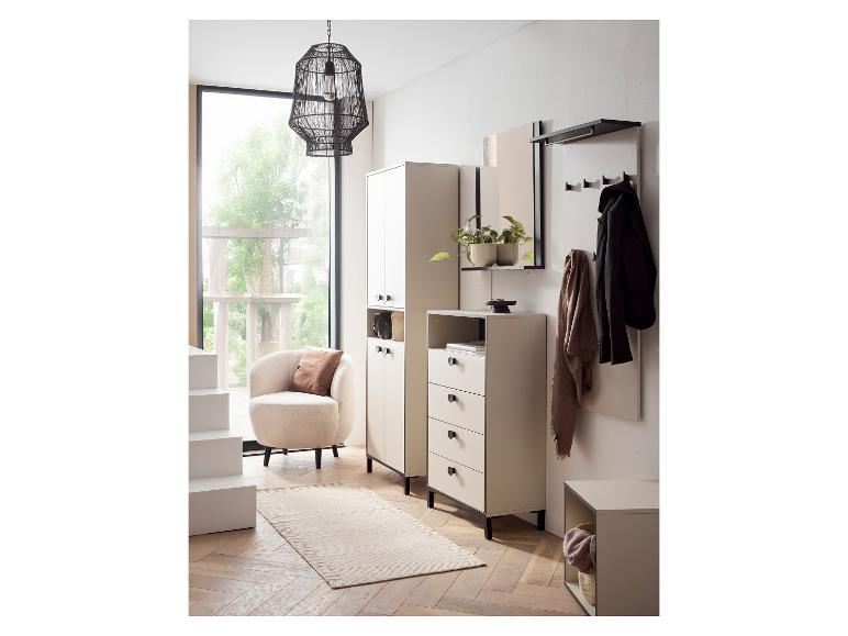 Meubles d'entrée beiges et noirs avec un fauteuil, un tapis et une grande fenêtre.