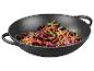 Wok en fonte avec légumes sautés.