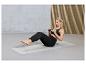 Une femme fait de l'exercice sur un tapis de yoga avec une haltère.