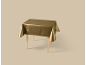 Nappe dorée sur une table en bois, placée sur un fond beige.
