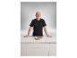 Andre Agassi présentant la poêle premium avec couche de cuivre sur un comptoir blanc.