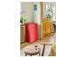 Mini-réfrigérateur rétro rouge dans un espace de vie moderne avec table et chaise en bois.