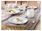 Table élégante avec vaisselle en porcelaine blanche, flûtes à champagne et desserts.