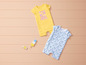 Deux bodies pour bébés avec un imprimé floral, un jaune avec l'inscription 'Flower Power' et un blanc avec des fleurs bleues.