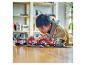 Un enfant joue avec un ensemble de train LEGO City sur une table en bois.