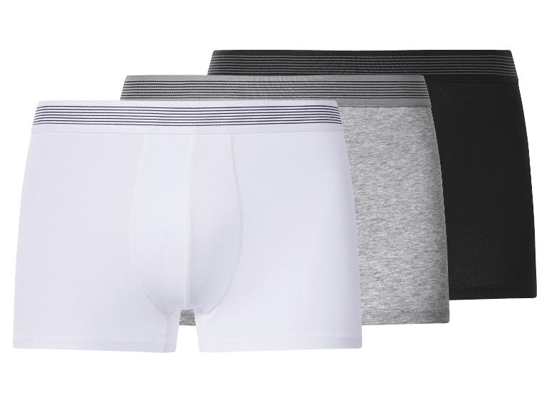 Trois boxers pour hommes en blanc, gris et noir avec des ceintures rayées.