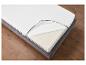 Un matelas en mousse avec un couvre-matelas sur un lit en tissu.
