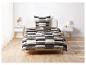 Un lit avec une couette rayée beige, noir et gris.
