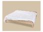 Couette blanche sur un lit en bois avec des draps beiges.