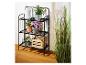 Étagère métallique noire avec plantes en pot et une boîte de rangement en bois.