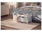 Banc de rangement blanc avec couvertures et livres dans une chambre avec couette florale.